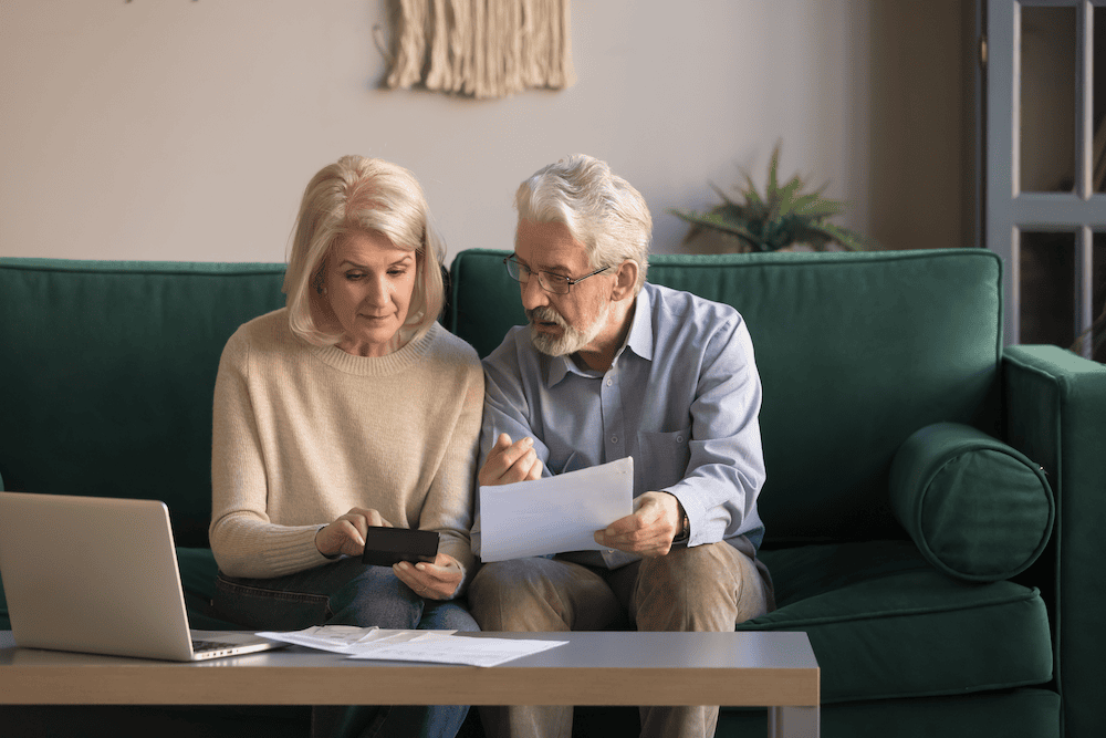 Two people sitting down look at paper