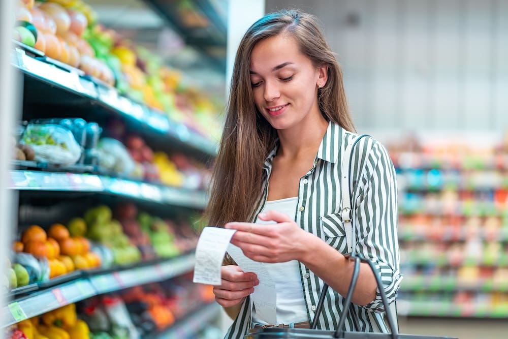 Woman in supermarket looking at receipt
